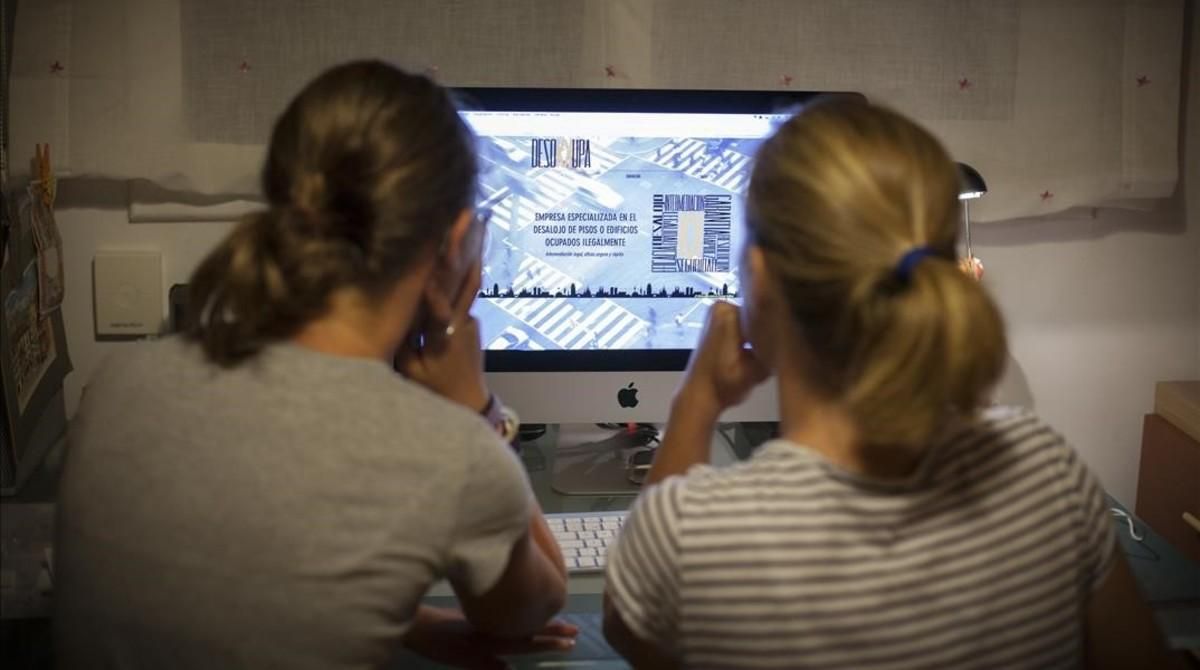 Dos personas consultan la web de Desokupa. Dos personas consultan la web de Desokupa.