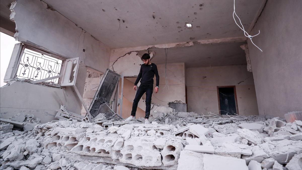 Un joven sirio camina por un edificio derrumbado por bombardeos de Damasco en el noroeste de Idleb, este lunes.