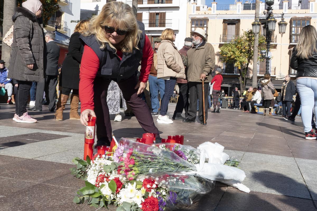 Una mujer coloca una vela en el lugar en el que fue asesinado el sacristán de la iglesia de La Palma, en Algeciras (Cádiz), este jueves. EFE/ David Arjona
