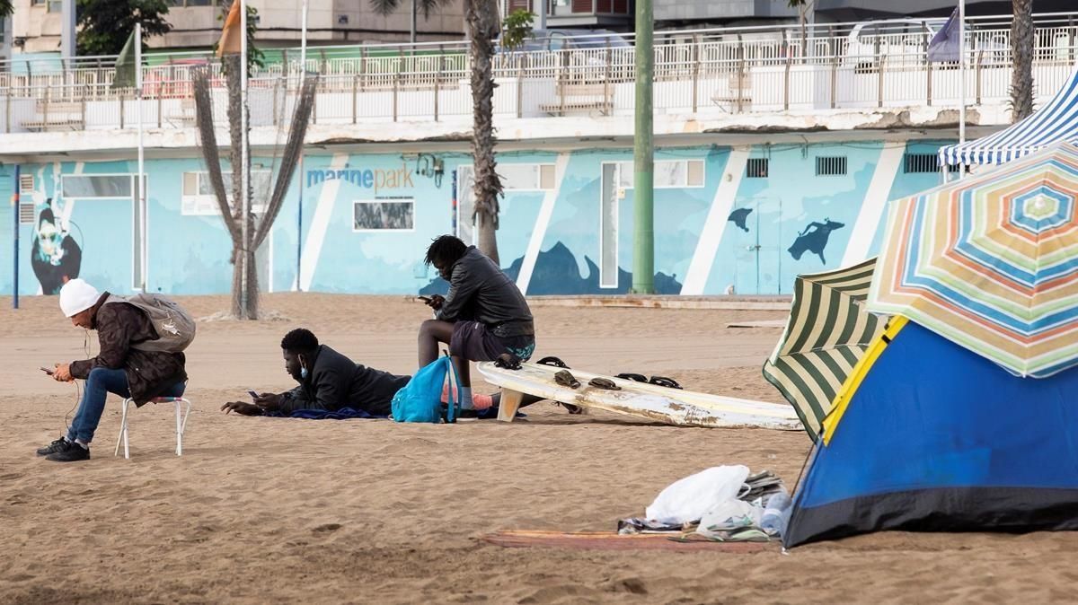Tres jóvenes en la playa de Las Alcaravaneras en Las Palmas de Gran Canaria, donde pernoctan varias personas. Tres jóvenes en la playa de Las Alcaravaneras en Las Palmas de Gran Canaria, donde pernoctan varias personas.