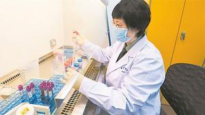 Una epidemióloga china investiga con muestras de coronavirus.