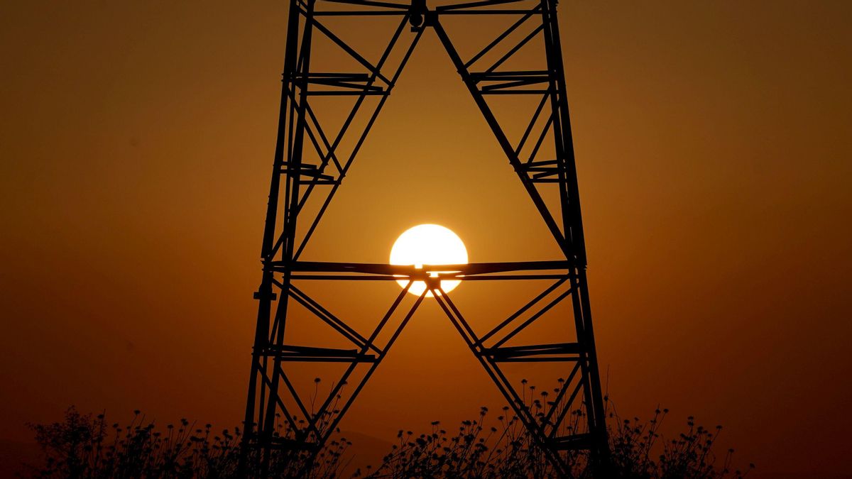Una torre eléctrica con la puesta de sol Una torre eléctrica con la puesta de sol