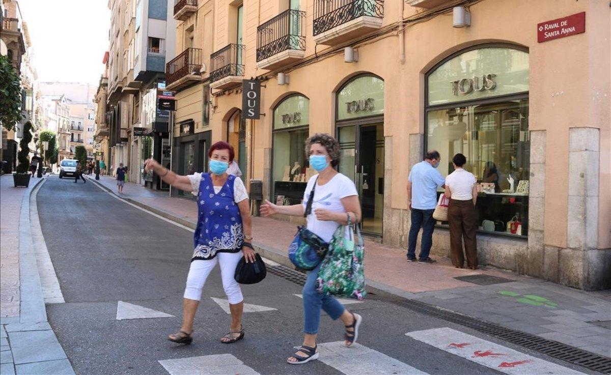 Peatones con mascarilla, en una calle de Reus.