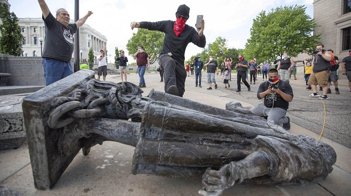 Varios hombres celebran el derribo de una estatua de Cristóbal Colón en Saint Paul (Minnesota), el 19 de junio. Varios hombres celebran el derribo de una estatua de Cristóbal Colón en Saint Paul (Minnesota), el 19 de junio.