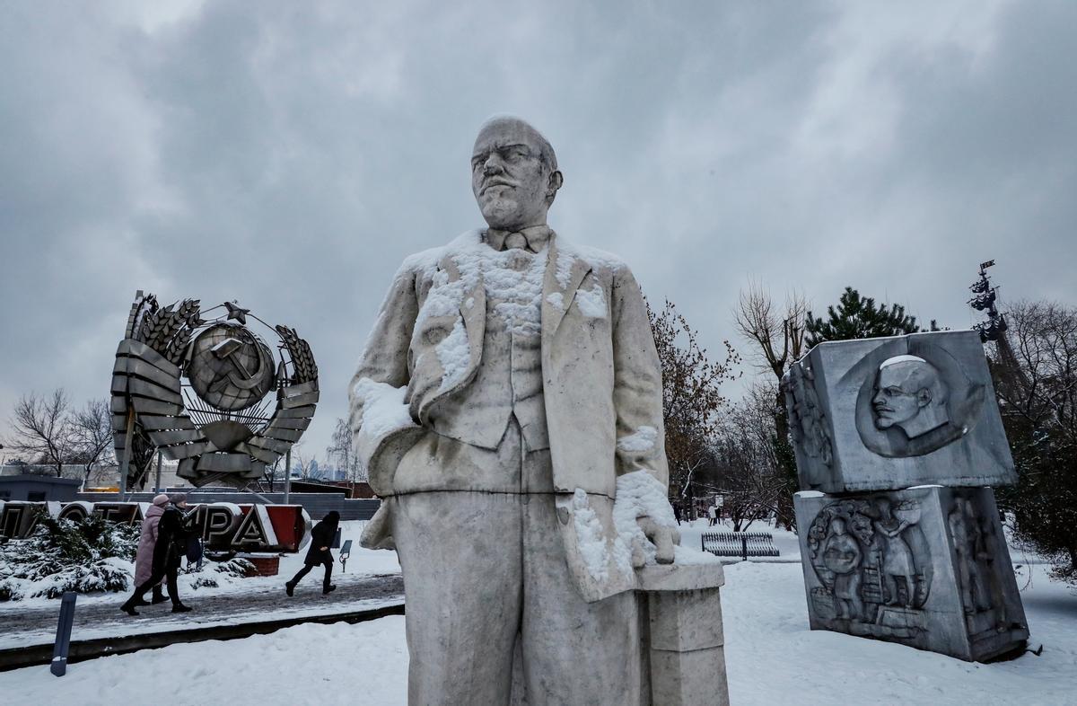 Varias personas caminan el pasado lunes junto a una estatua de Vladimir Ulyanov ’Lenin’ y otros monumentos de la URSS en un parque de Moscú