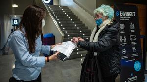 Una mujer muestra su pasaporte covid a su llegada al cine Bosque, en Barcelona.