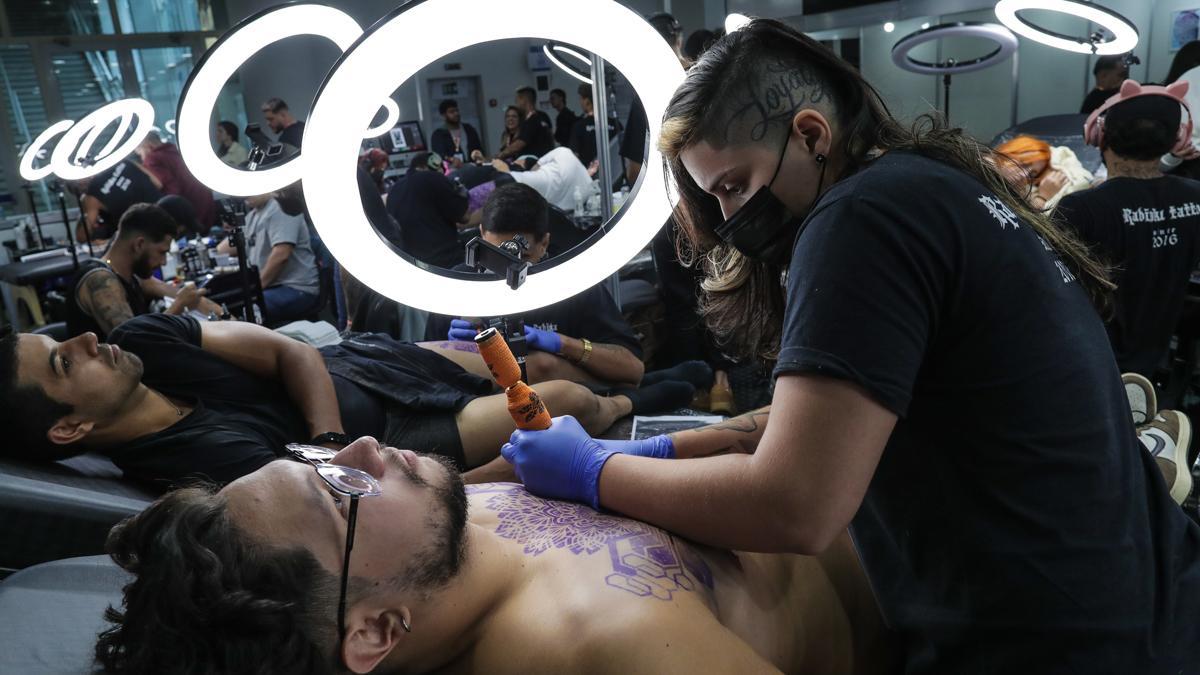 Un tatuador realiza un tatuaje en un festival de esta disciplina en Río de Janeiro.