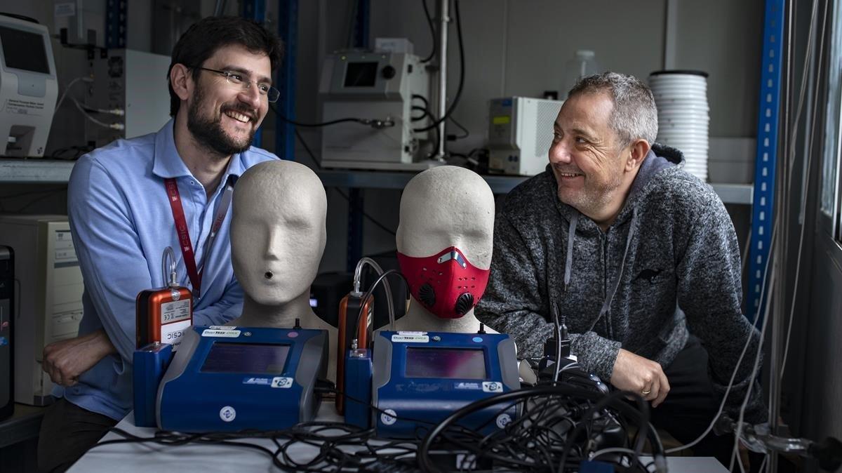 Fulvio Amato (izquierda) y Xavier Querol, investigadores del CSIC, con su dispositivo para estudiar la efectividad de las mascarillas para ciclistas.