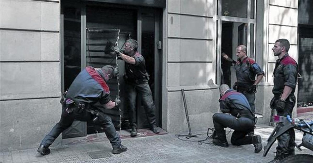 Unos mossos d’esquadra derriban la puerta del club cannábico Hardala en la calle de Bailén de Barcelona, ayer. Unos mossos d’esquadra derriban la puerta del club cannábico Hardala en la calle de Bailén de Barcelona, ayer.