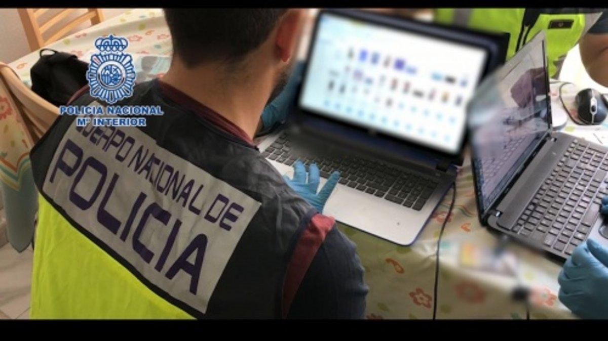 Un agente busca material en un ordenador intervenido. Un agente busca material en un ordenador intervenido.