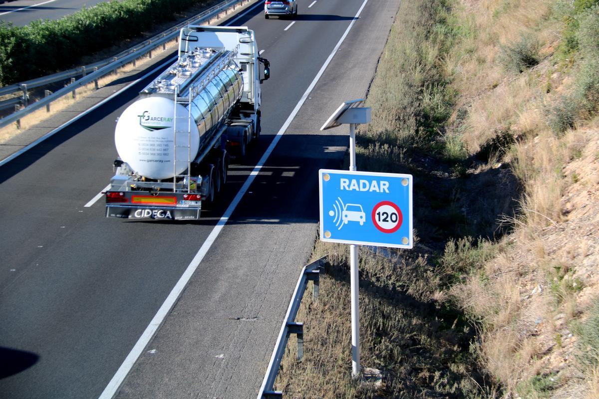 Un camión pasa al lado de una señal que informa de un radar fijo en la AP-7