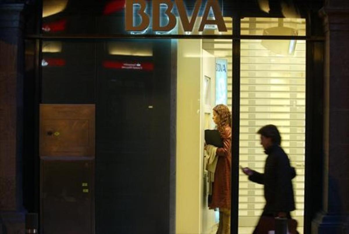 Una mujer utiliza un cajero de una oficina del BBVA en Barcelona.