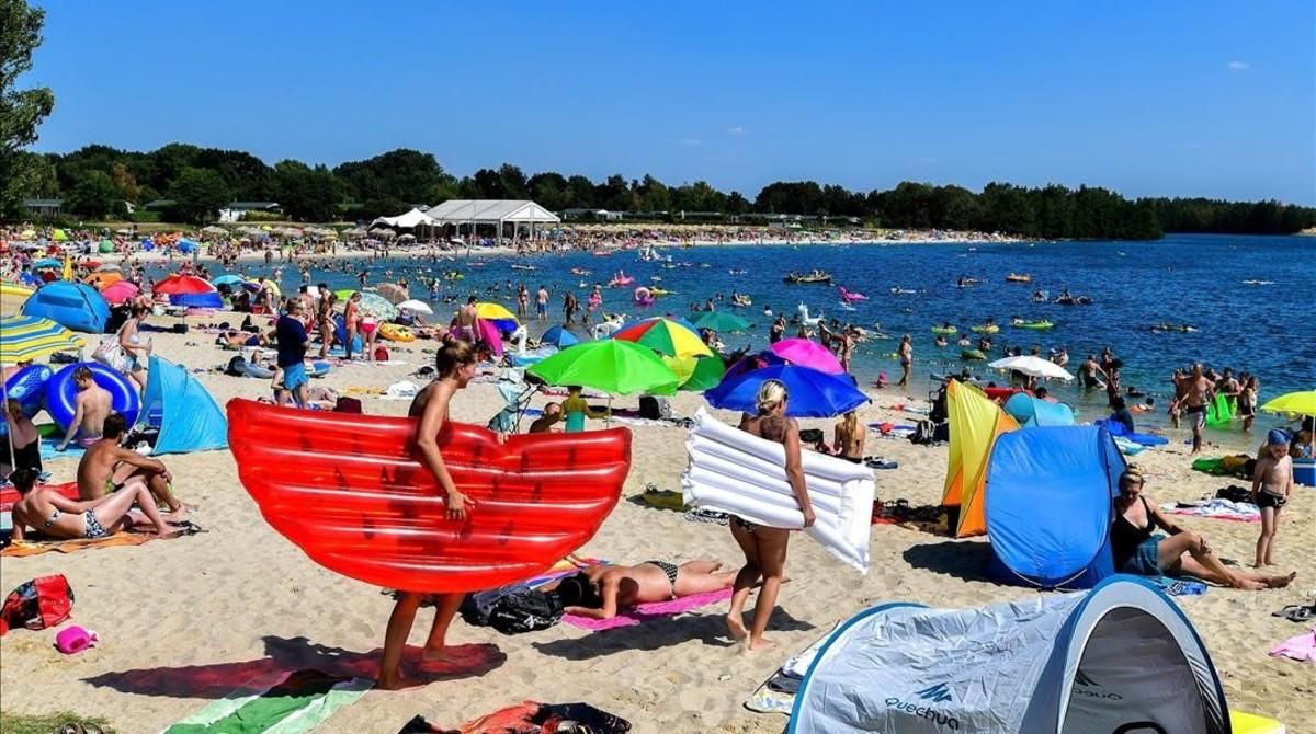 Numerosas personas disfrutan del buen tiempo en el Blue Lagoon de Wachtendonk, Alemania, ayer. Numerosas personas disfrutan del buen tiempo en el Blue Lagoon de Wachtendonk, Alemania, ayer.