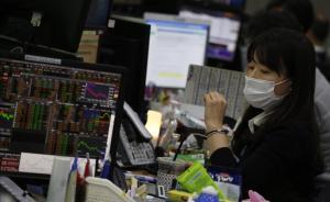 Una agente de bolsa trabaja con máscara protectora en Seúl.