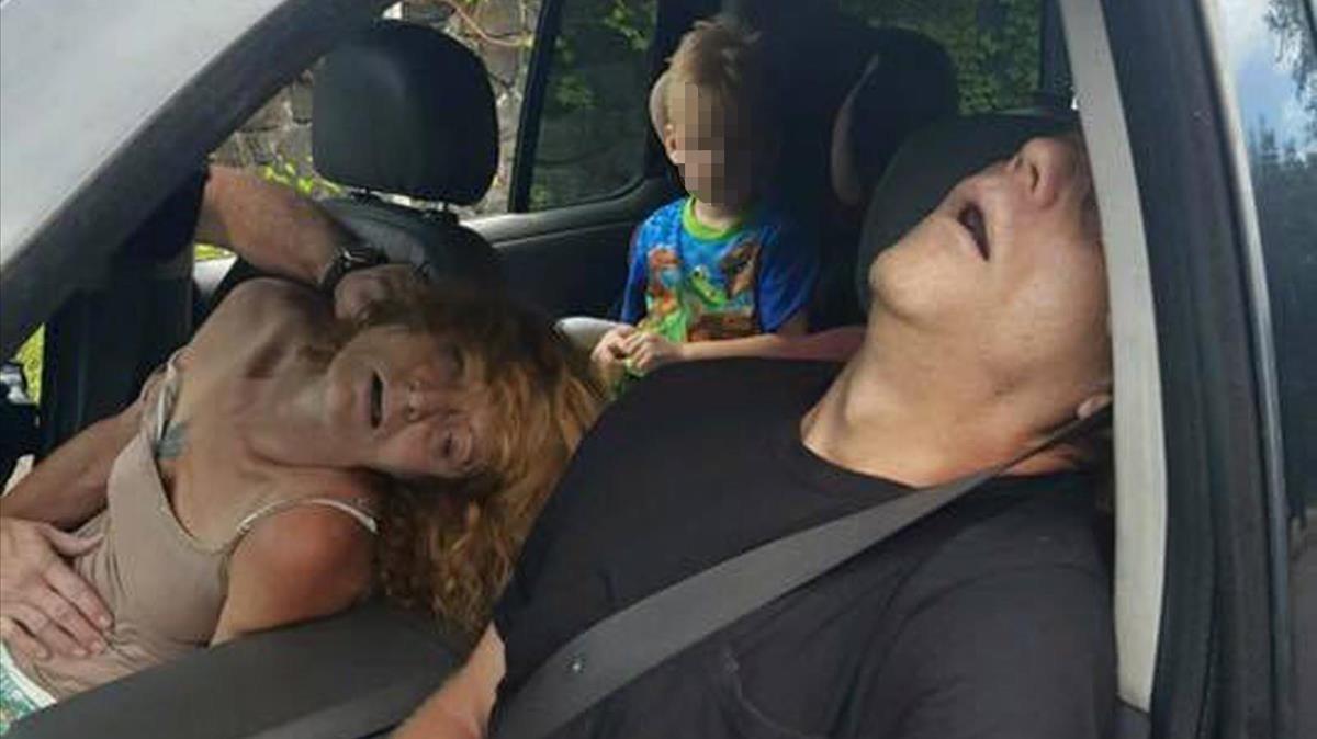 Un niño en el asiento trasero de un coche, con su madre y un hombre incoscientes por el consumo de heroína, en East Liverpool, estado de Ohio, en septiembre del 2016.