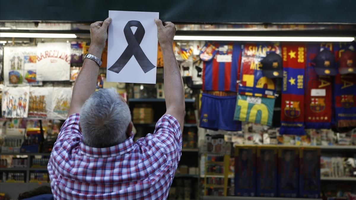 Un quiosquero de la Rambla, coloca un lazo simbólico en memoria de las víctimas. Un quiosquero de la Rambla, coloca un lazo simbólico en memoria de las víctimas.