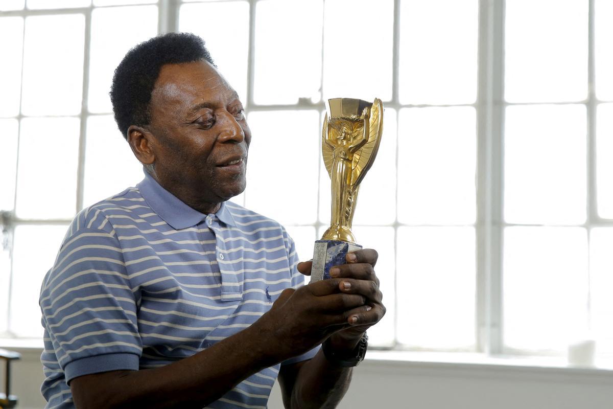 Pelé, en una imagen de archivo, con la reproducción del trofeo de la Copa del Mundo de 1958