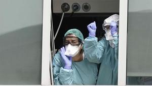 Dos sanitarias saludan desde una ventana de una de las UCIs del Hospital La Paz de Madrid, el pasado 18 de marzo.