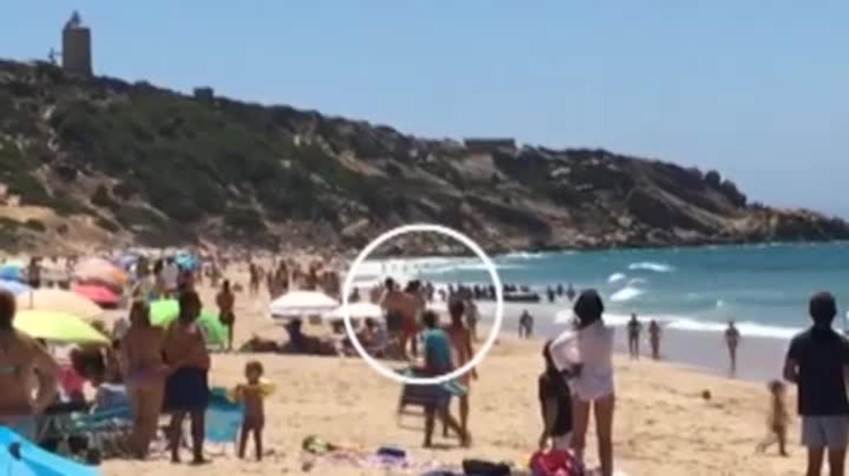 Bañistas sorprendidos por la llegada de una patera con una cincuentena de inmigrantes en la playa de los Alemanes en Cádiz