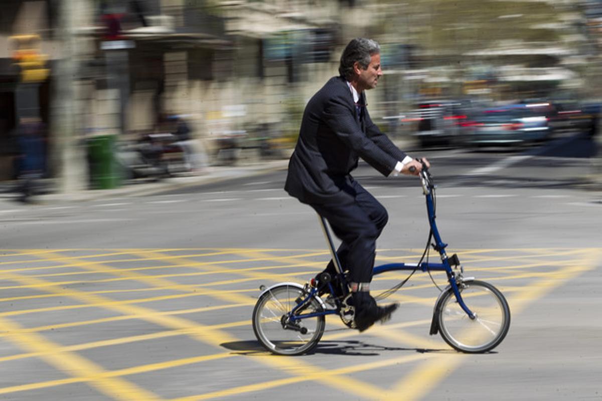Un hombre pedalea en su bicicleta plegable, el modelo más aconsejado por los expertos, este martes, en València con Sant Joan.