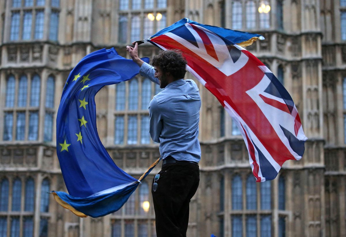 Un joven ondea las banderas británica y europea frente al Parlamento del Reino Unido. Un joven ondea las banderas británica y europea frente al Parlamento del Reino Unido.