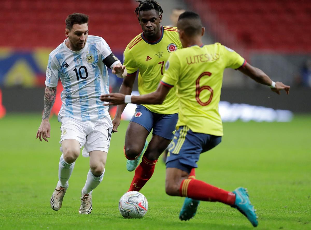 Messi conduce el balón ante dos jugadores de Colombia.