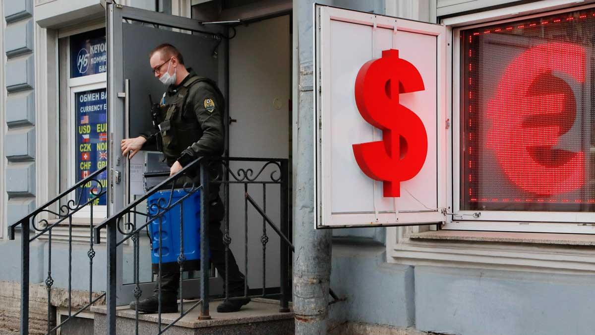 Rusia impone un corralito a las monedas extranjeras. En la foto, un trabajador de transporte de efectivo sale de una oficina de cambio de moneda en San Petersburgo.