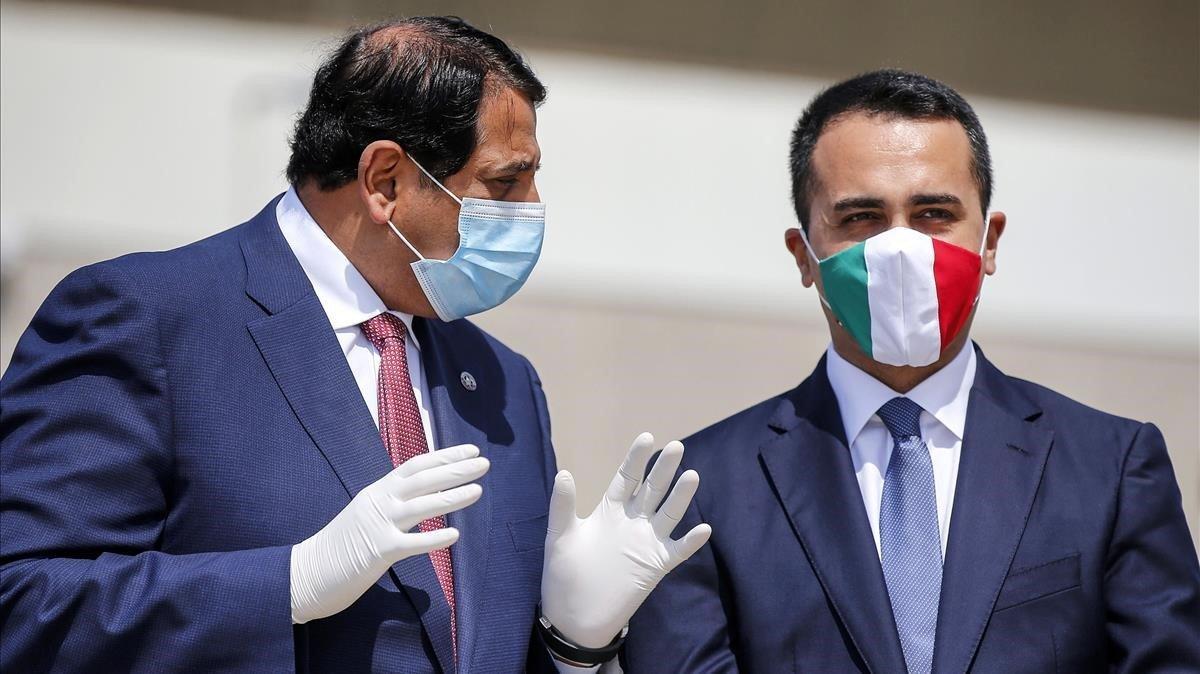 El ministro de Exteriores italiano, Luigi di Maio, luce una máscara protectora con los colores de la bandera italiana al dar la bienvenida al embajador de Qatar en Italia, Abdulaziz bin Ahmed Al Malki durante la llegada de un vuelo con ayuda médica del país árabe, este lunes, en Roma. 