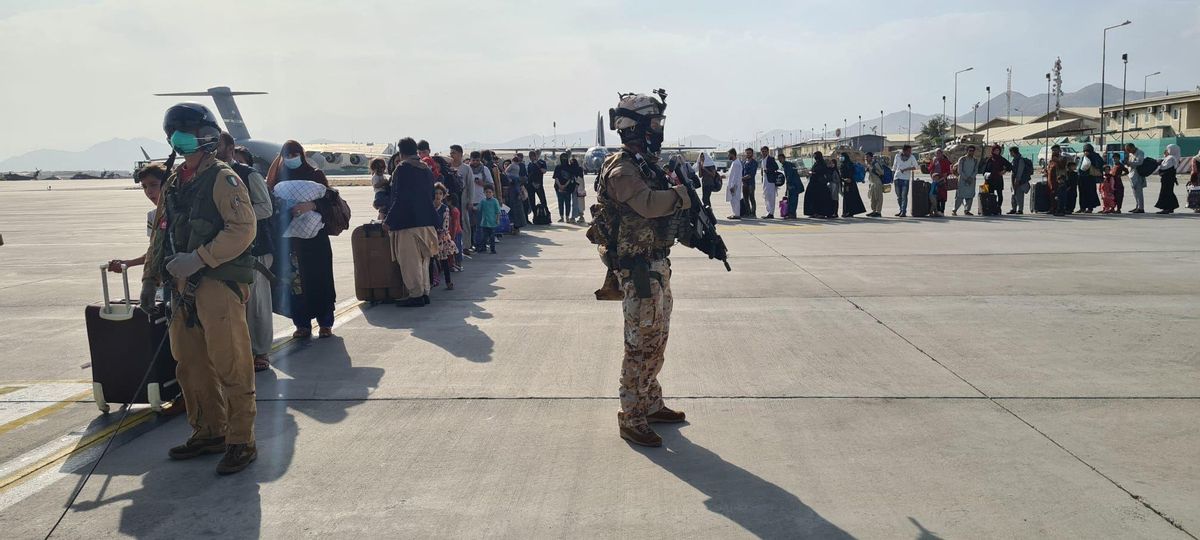 Ciudadanos afganos hacen cola para subir a un avión militar italiano en el aeropuerto de Kabul Ciudadanos afganos hacen cola para subir a un avión militar italiano en el aeropuerto de Kabul