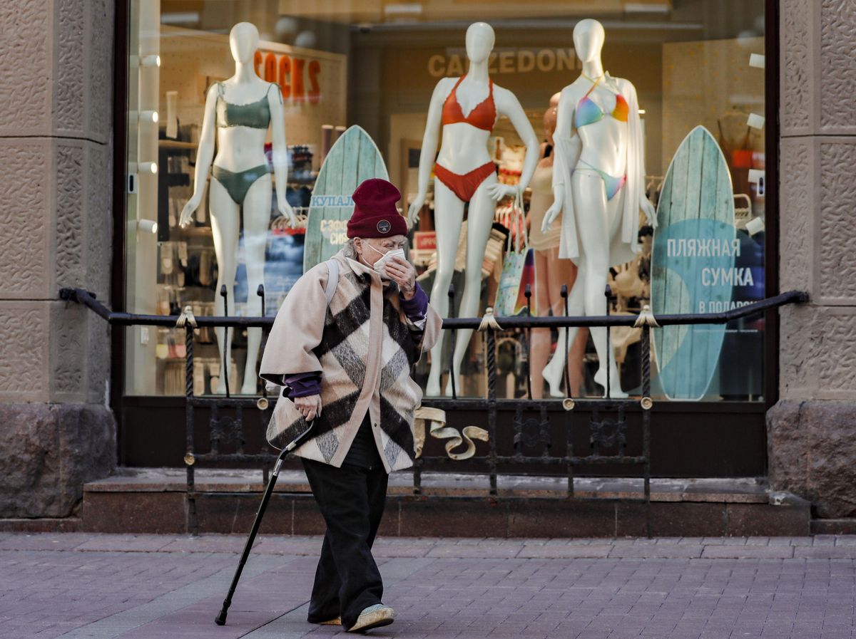 Una mujer con mascarilla camina por una calle comercial de Moscú. Una mujer con mascarilla camina por una calle comercial de Moscú.