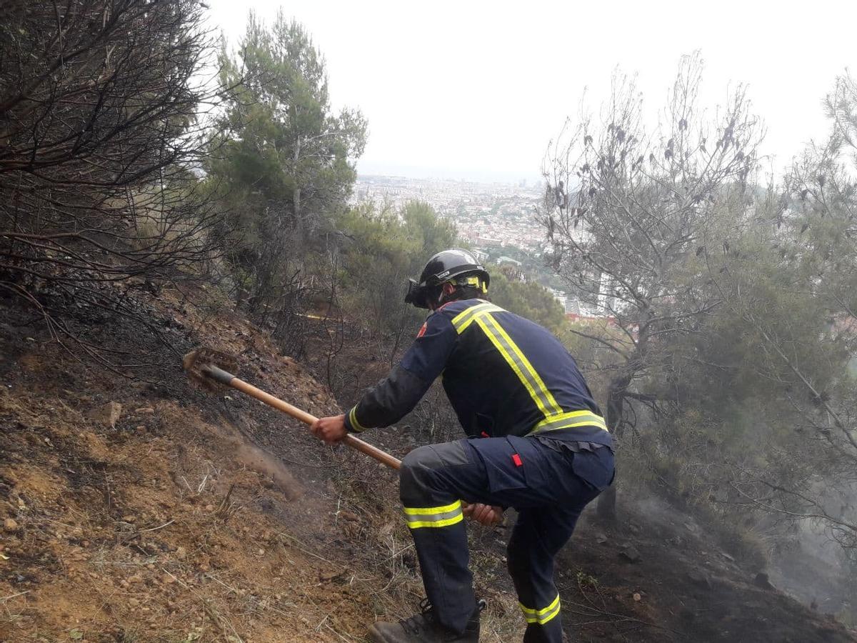 Un bombero extingue el incendio en Collserola en mayo del 2021.