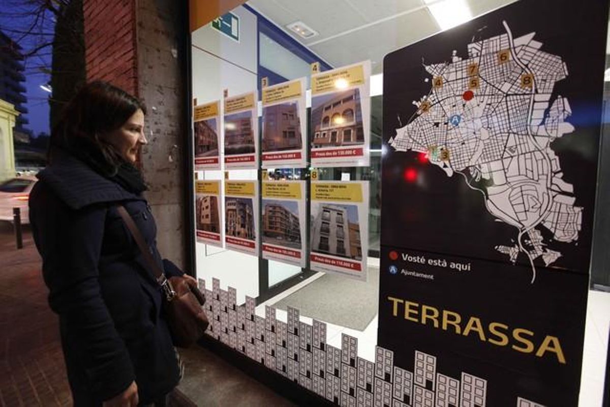 Una mujer mira precios de pisos en una inmobiliaria de Terrassa. Una mujer mira precios de pisos en una inmobiliaria de Terrassa.
