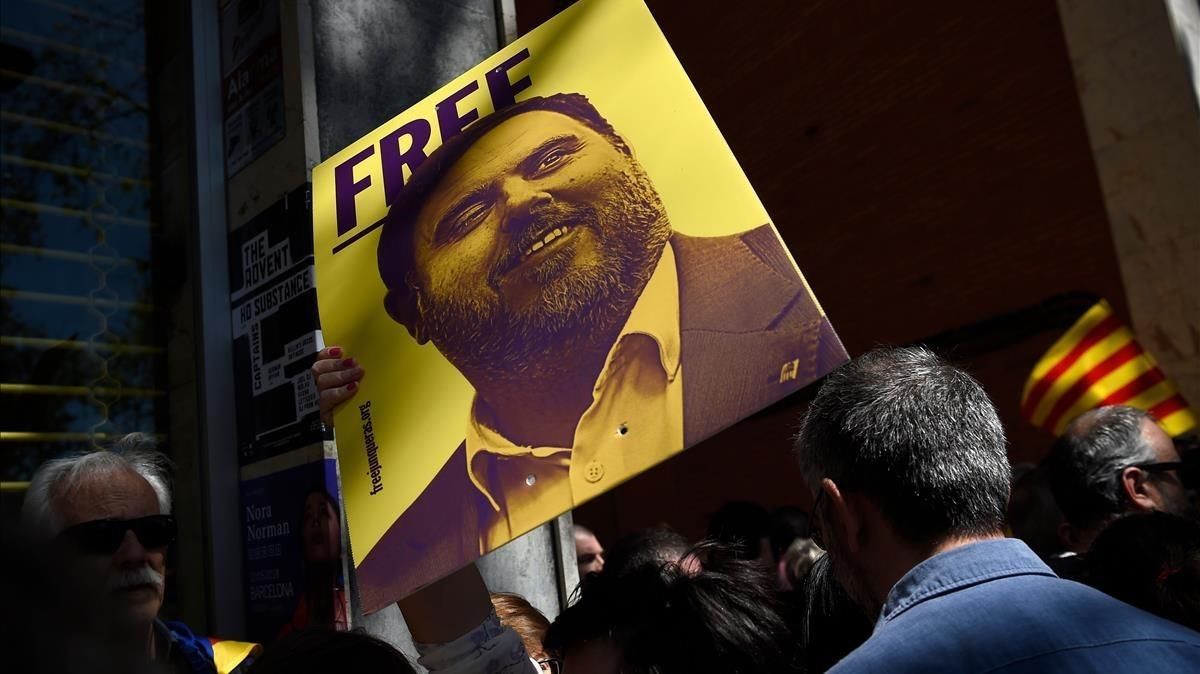 Una persona sostiene un cartel con el rostro de Junqueras durante una manifestiación independentista. Una persona sostiene un cartel con el rostro de Junqueras durante una manifestiación independentista.