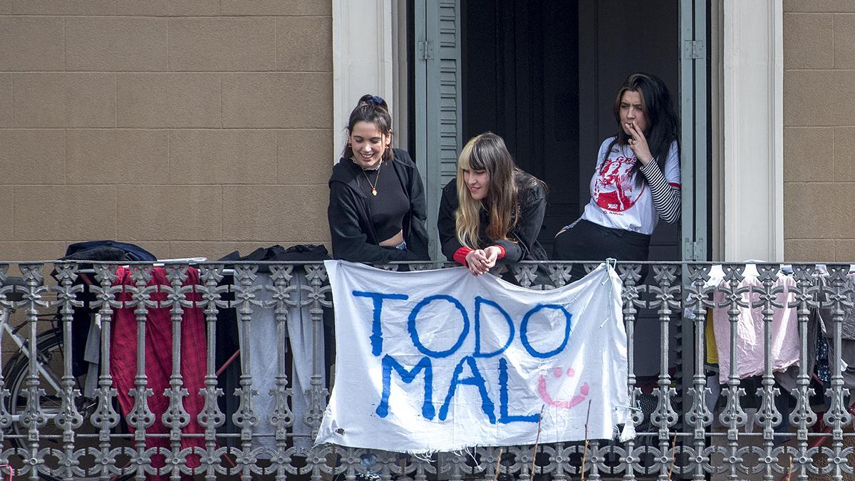’Todo mal’, la queja de tres jóvenes desde su balcón del Eixample, en Barcelona, durante la pandemia.
