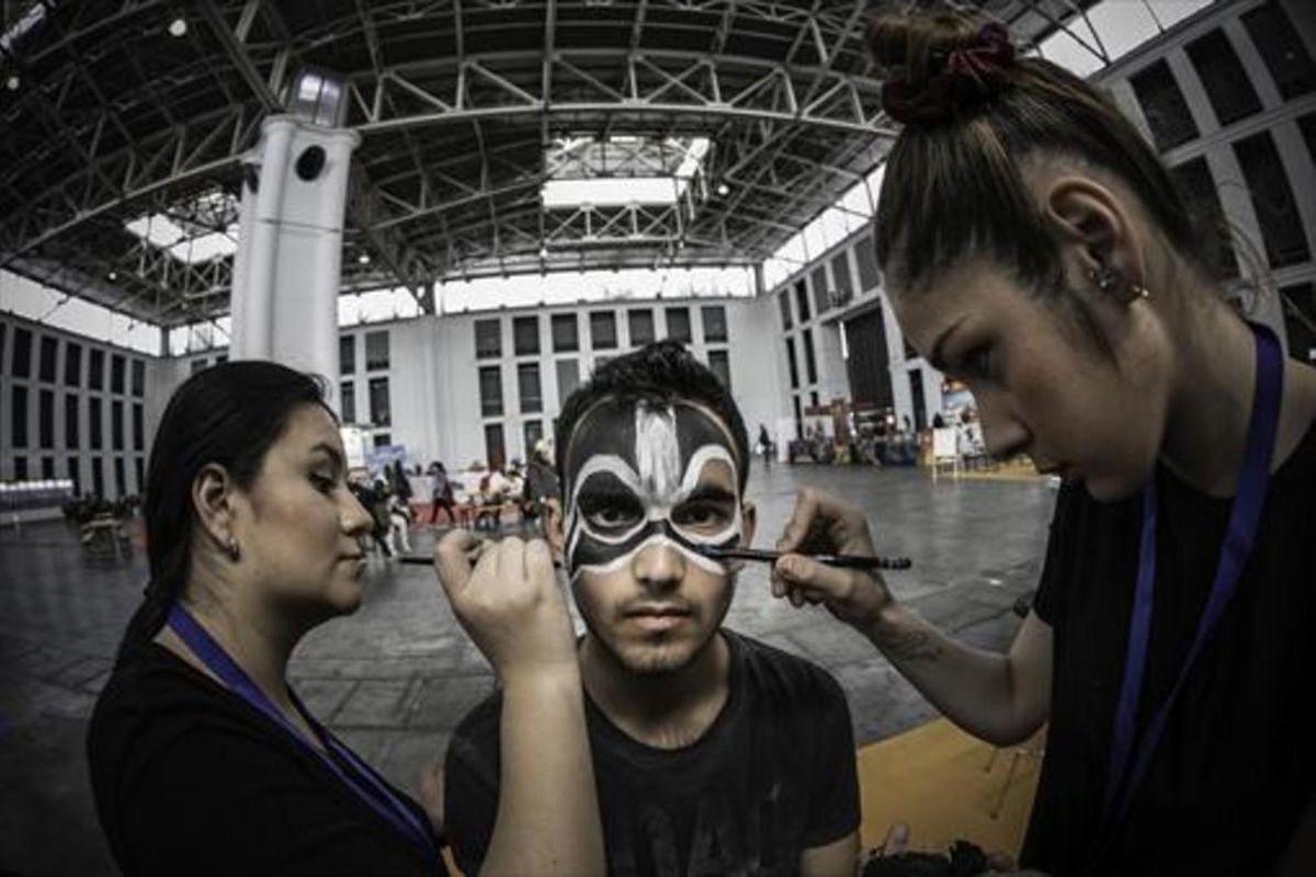 Dos monitoras maquillan a un joven visitante del Saló del Cómic, que se celebra en el recinto ferial de Montjuïc. Dos monitoras maquillan a un joven visitante del Saló del Cómic, que se celebra en el recinto ferial de Montjuïc.