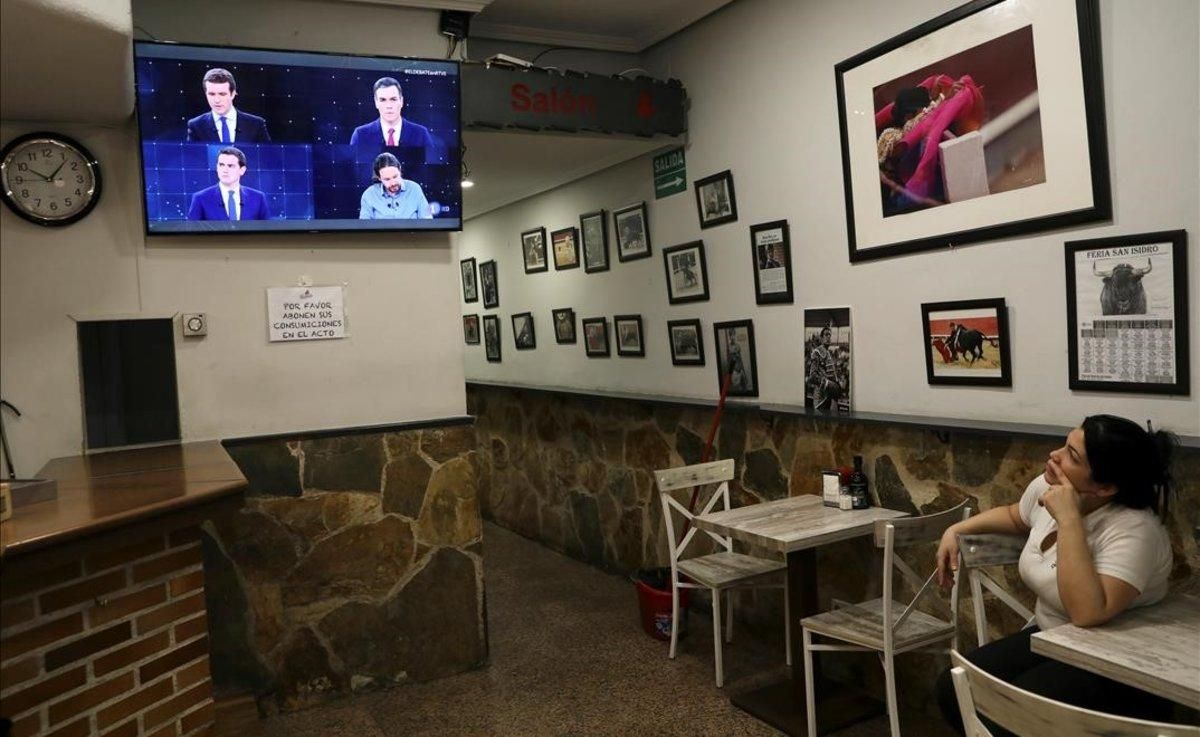 Una empleada de un bar mira el debate de TVE. Una empleada de un bar mira el debate de TVE.