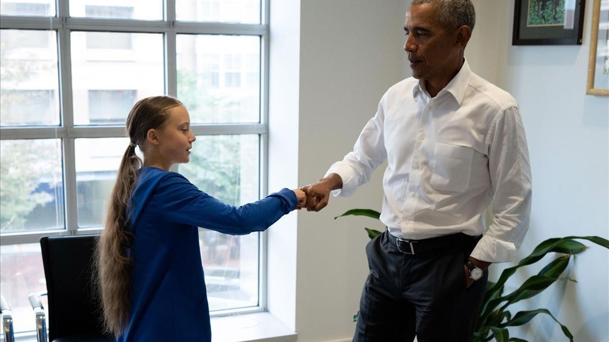 Greta Thunberg y Barak Obama chocan los puños, este miércoles. 