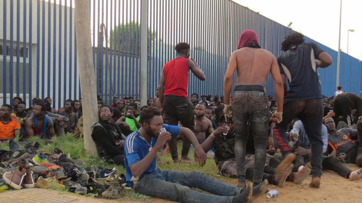 Un grupo de migrantes de origen subsahariano, a las puertas del Centro de Estancia Temporal de Inmigrantes (CETI) de Melilla, después de haber saltado la valla con Marruecos, a 22 de julio de 2021.