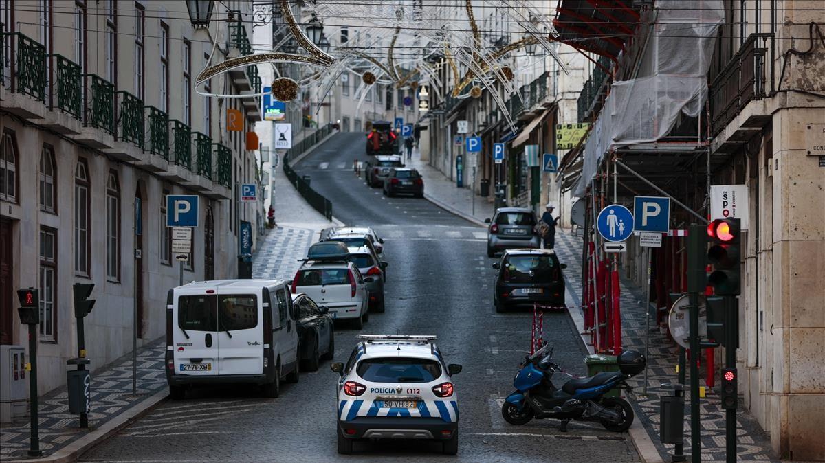 Una de las calles de Lisboa completamente vacía, solo con un coche patrulla de la policía, durante el toque de queda.