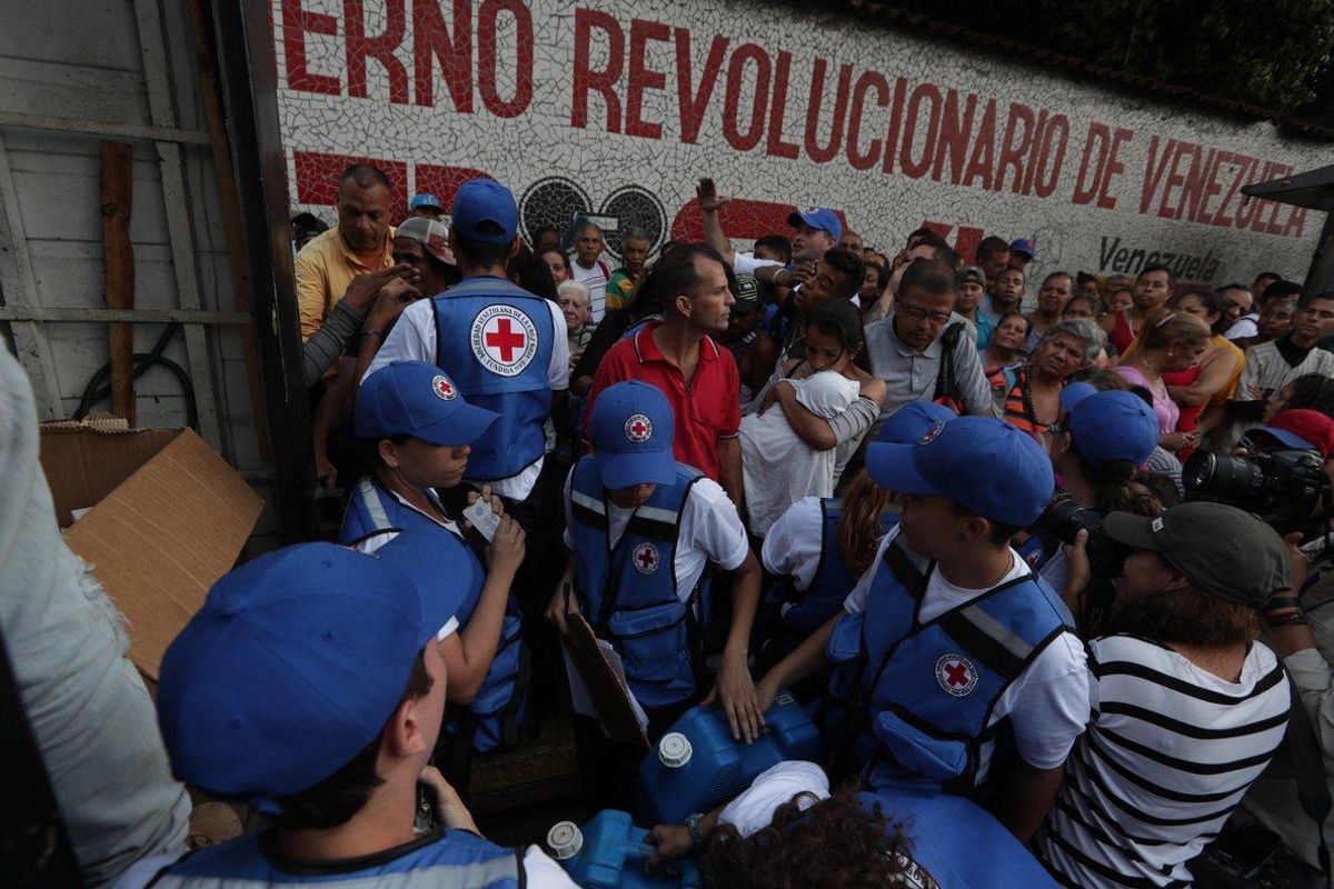Miembros de la Cruz Roja reparten el primer cargamento de ayuda humanitaria que llegó a Venezuela. Miembros de la Cruz Roja reparten el primer cargamento de ayuda humanitaria que llegó a Venezuela.