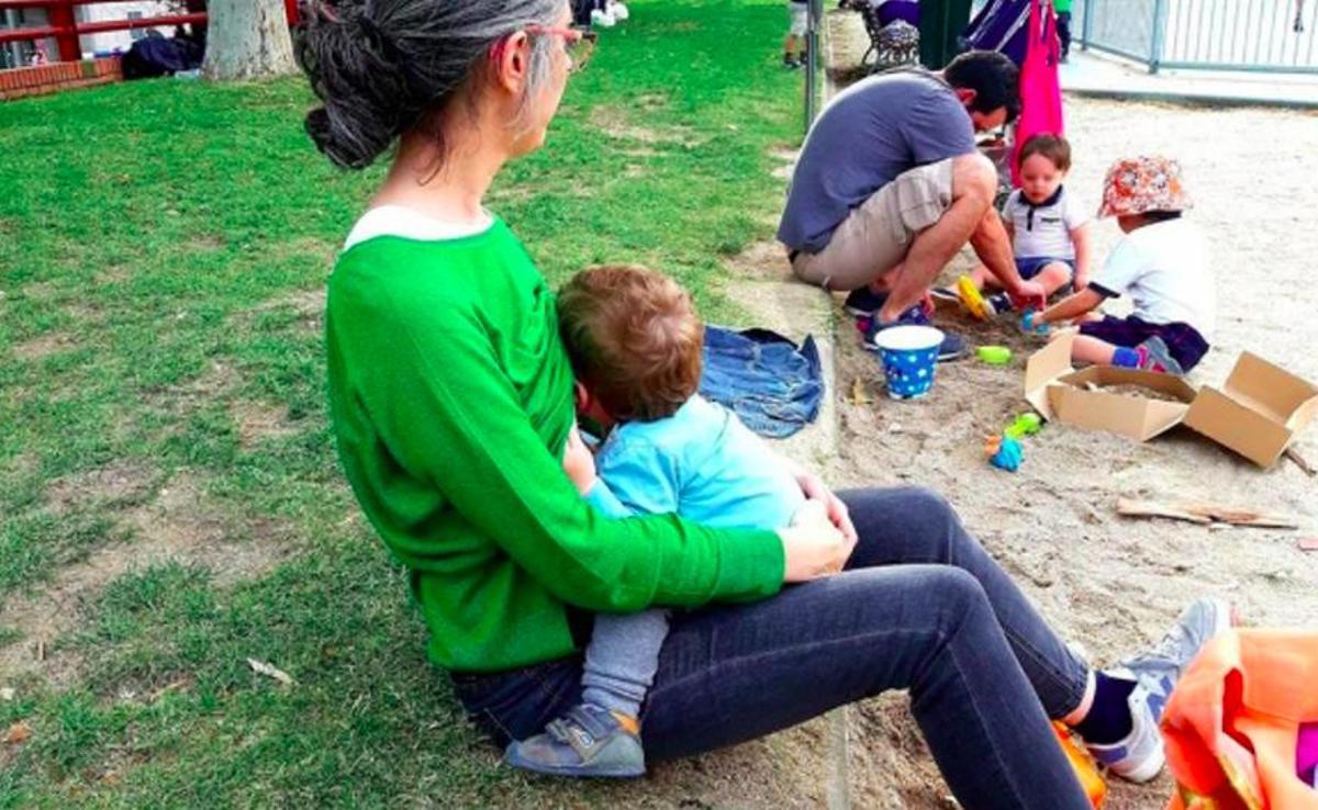 Una madre amamanta a su bebé en un parque de Madrid