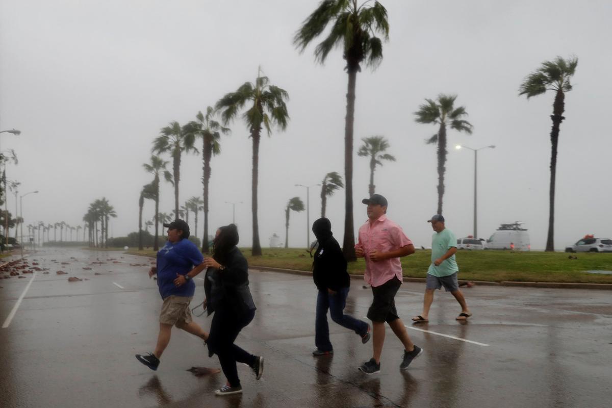 Un grupo de personas corre a refugiarse ante la llegada del huracán ’Harvey0, en Corpus Christi (Texas).