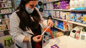 Una farmacéutica de la Farmacia Marta Bosch, en El Prat de Llobregat, muestra el ’kit’ de autodiagnóstico del virus del papiloma humano.