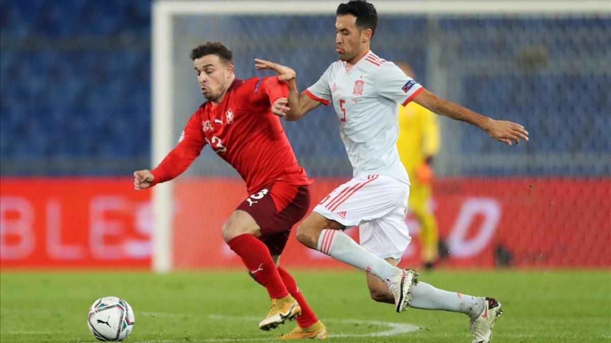 Sergio Busquets y Xherdan Shaqiri pugnan por un balón durante el partido. Sergio Busquets y Xherdan Shaqiri pugnan por un balón durante el partido.