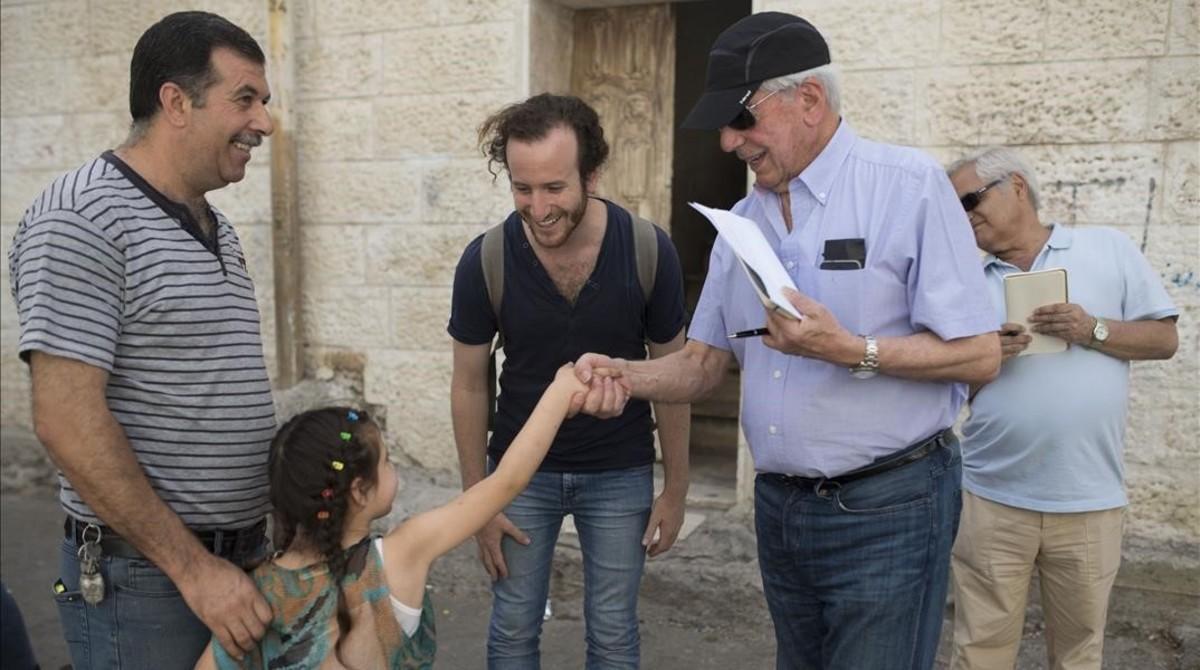 Vargas Llosa saluda a una familia en el barrio de Silwan, en Jerusalén este.