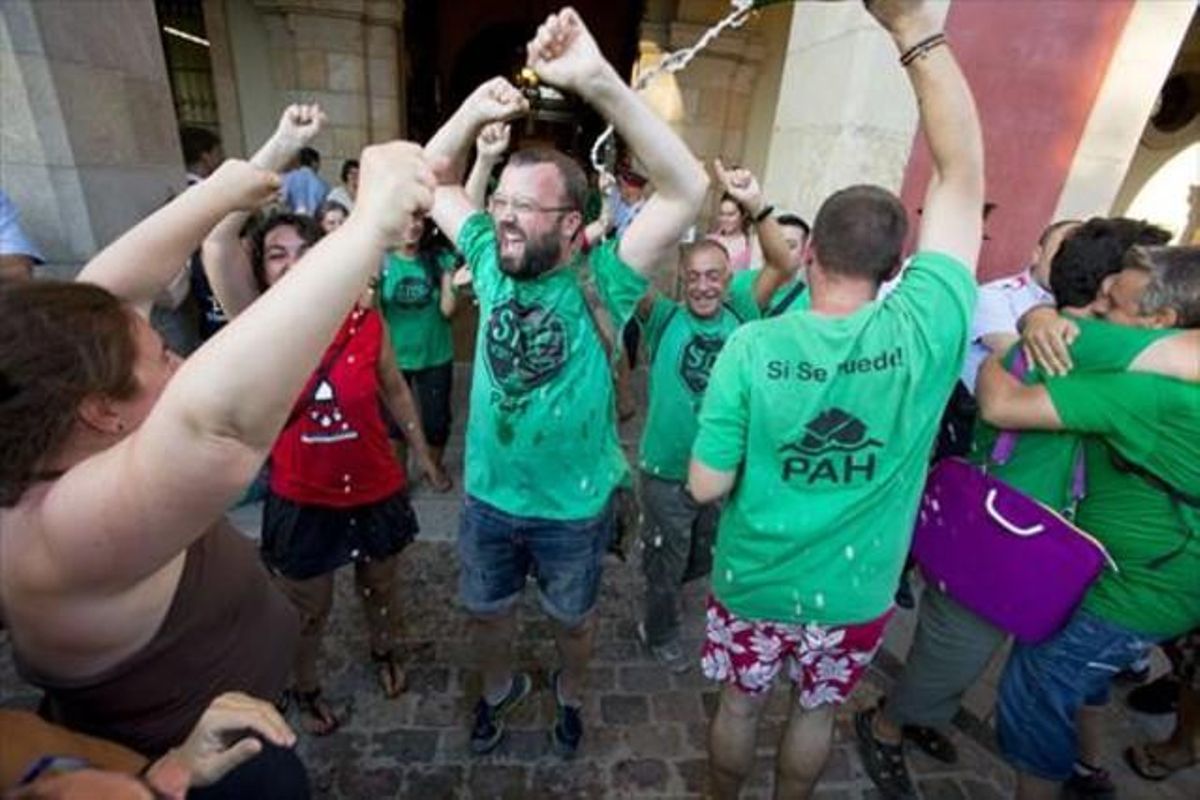 Macías (con barba) celebra frente al Parlament, en julio del 2015, la aprobación de la ley 24/2015, que se basó en una ilp apoyada entre otros por la PAH. Macías (con barba) celebra frente al Parlament, en julio del 2015, la aprobación de la ley 24/2015, que se basó en una ilp apoyada entre otros por la PAH.