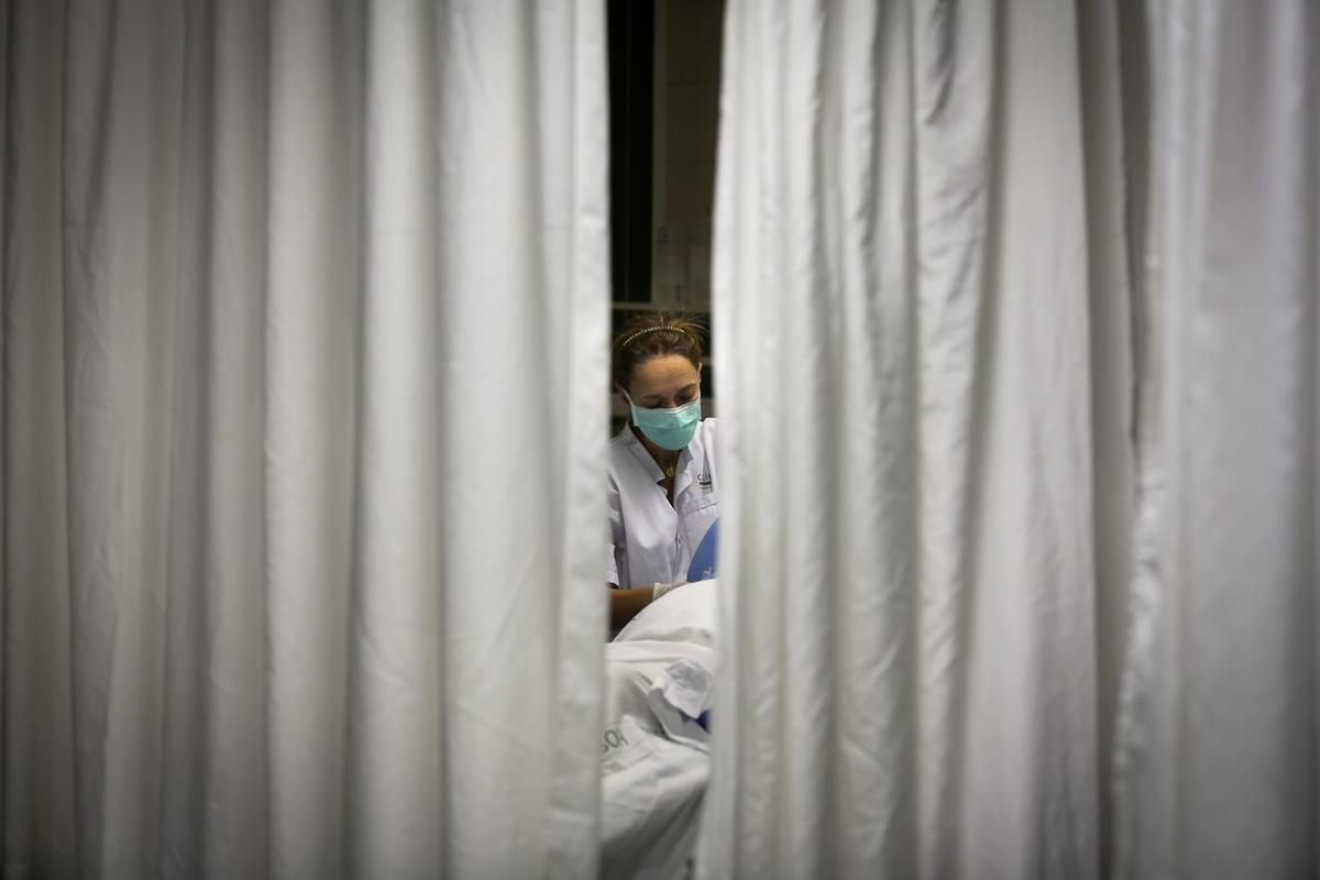 Una enfermera atiende a un paciente en la UCI del Hospital Clínic de Barcelona.