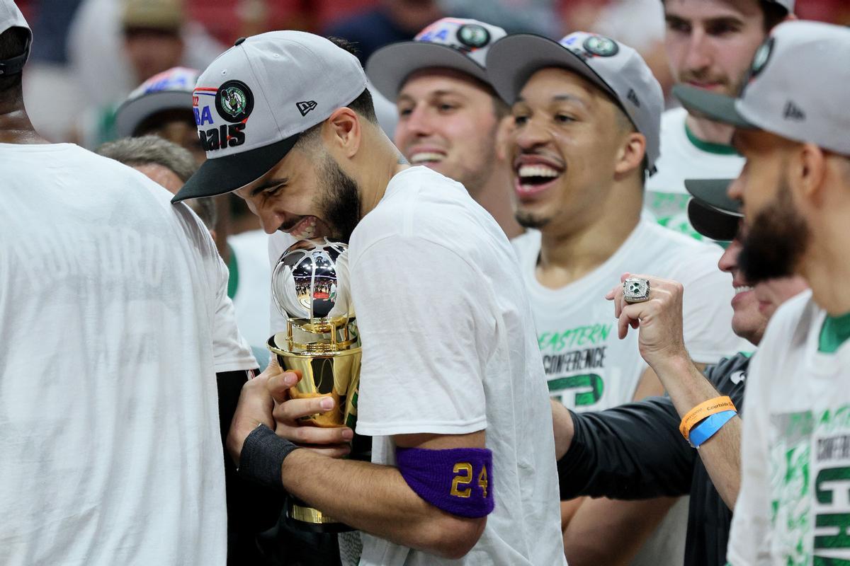 Tatum abraza su trofeo de MVP, que recibió tras el triunfo en Miami, mientas es felicitado por sus compañeros