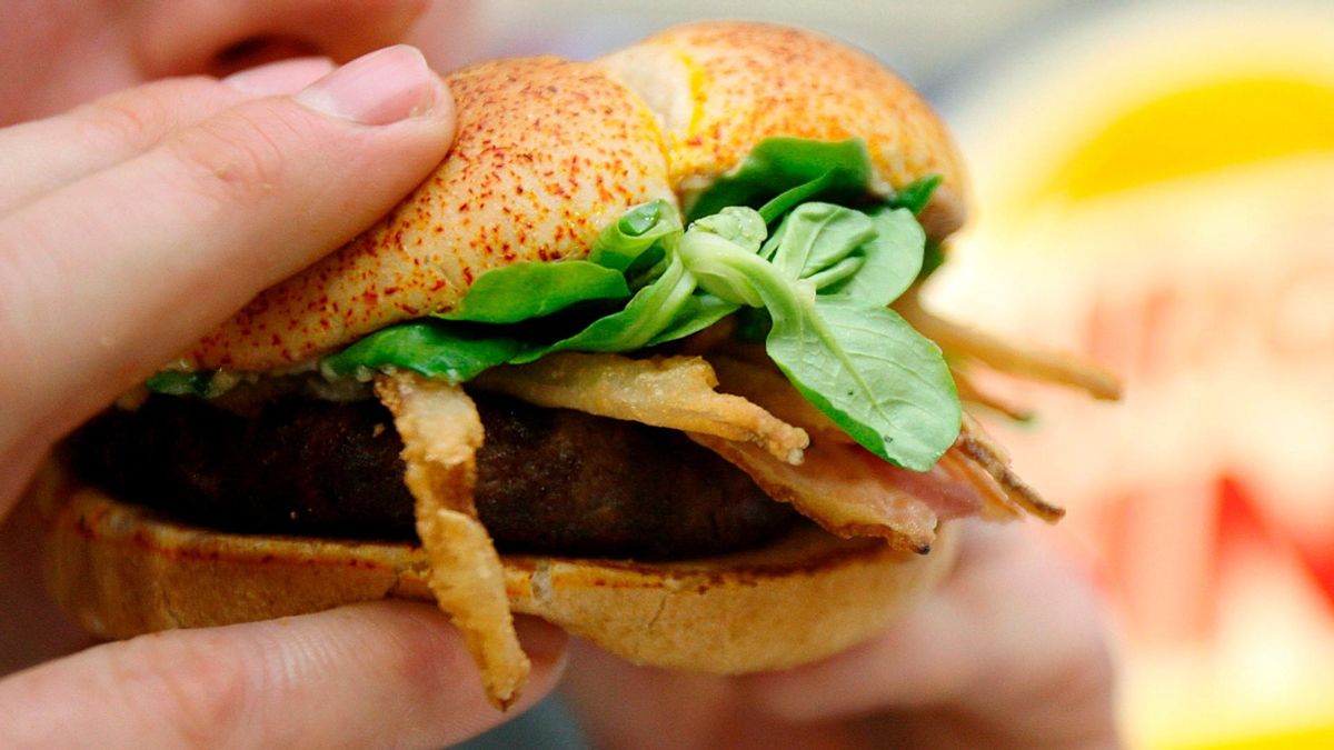Una persona come una hamburguesa especial en un Burger King de Londres. Una persona come una hamburguesa especial en un Burger King de Londres.