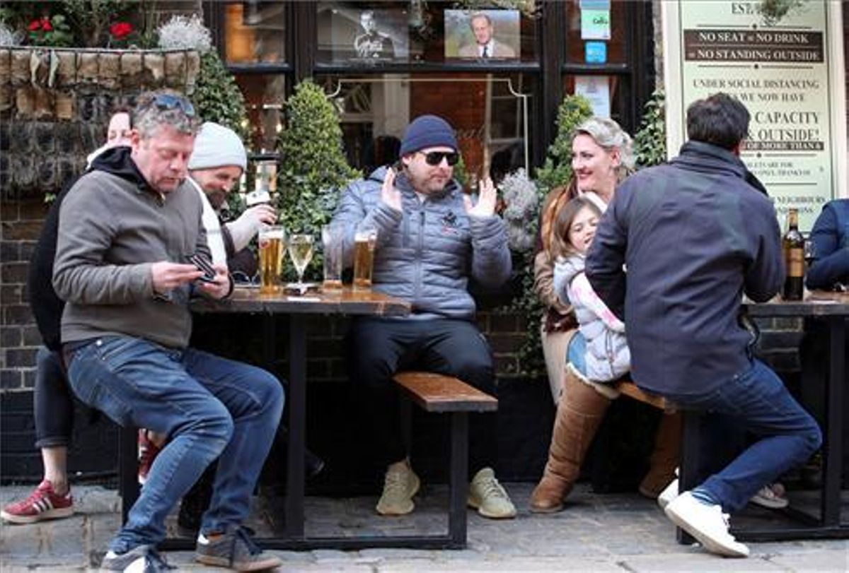 Ciudanos londinenses saborean su cerveza en un pub . Ciudanos londinenses saborean su cerveza en un pub .